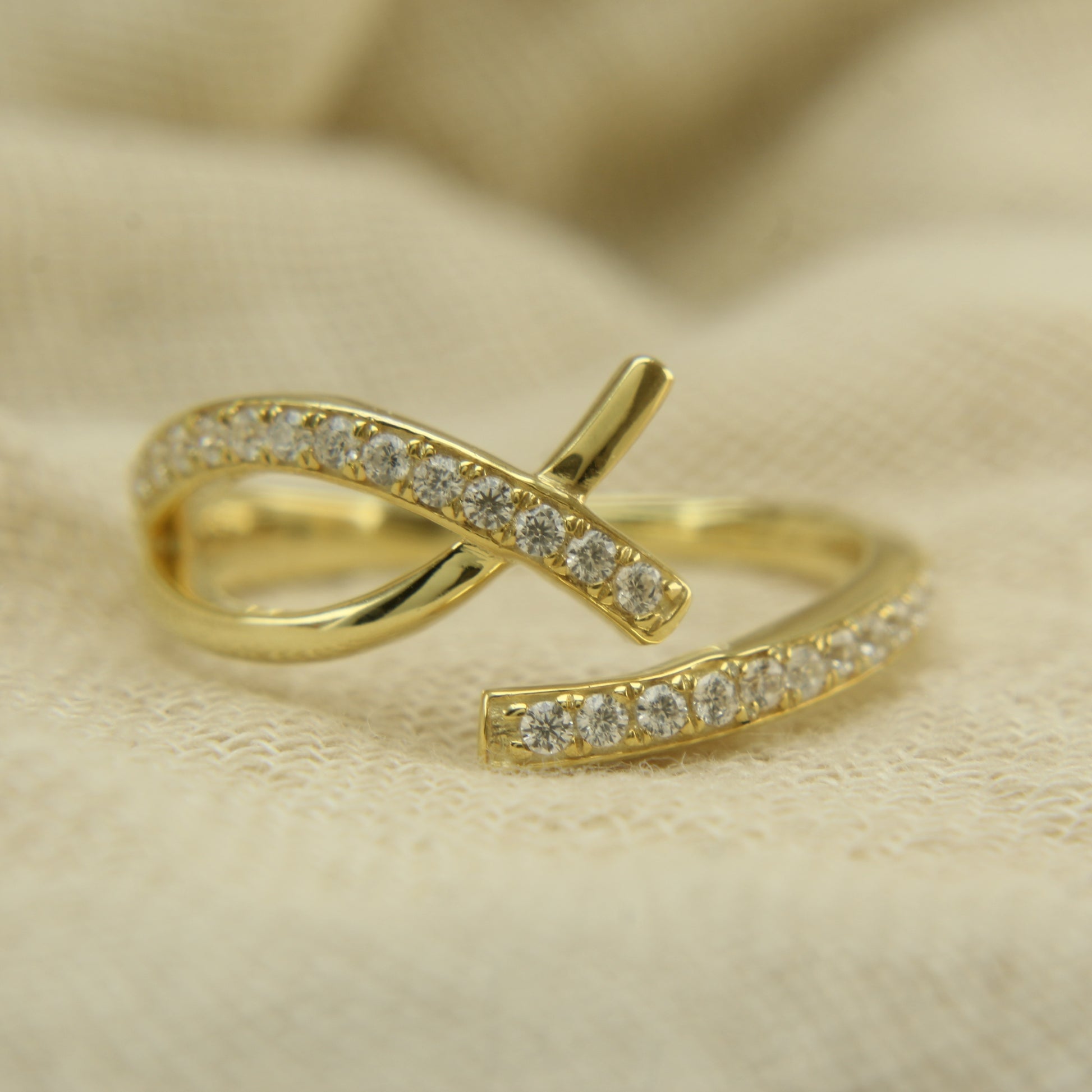 Micropavé diamond ring showcased in sustainable packaging, Elegant diamond crossover ring resting on velvet cushion, 
