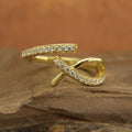 Close-up of handmade diamond crossover ring in recycled gold, Side view of natural diamond ring with micropavé setting,