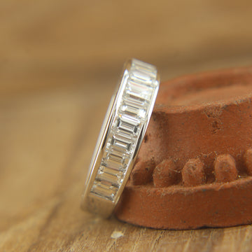 On-hand display of minimalist baguette diamond wedding band, highlighting its sleek design.