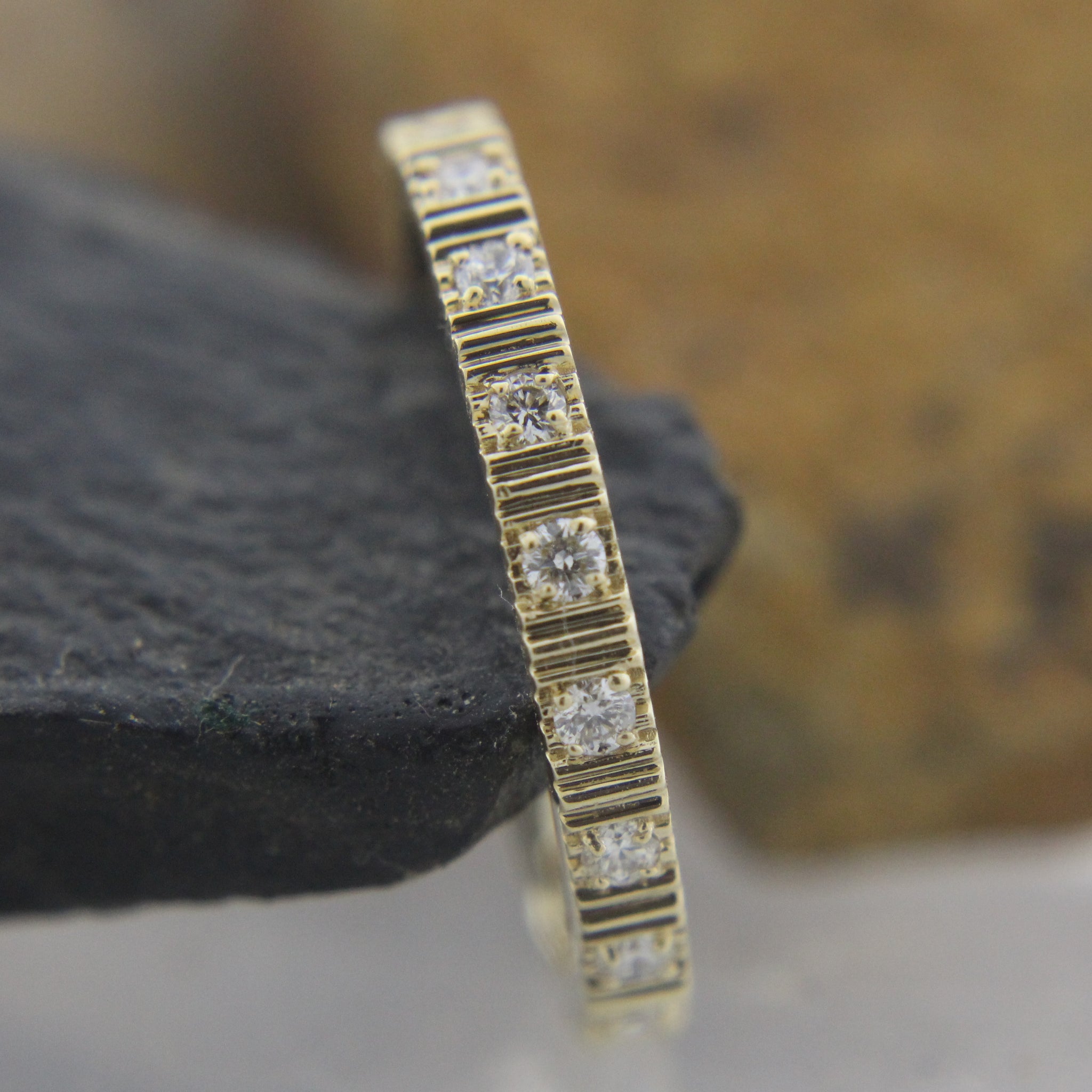 Natural diamond eternity band in 14k gold close-up showing sparkle and micro-pave setting,
Side view of recycled gold eternity band with round diamonds in seamless setting,