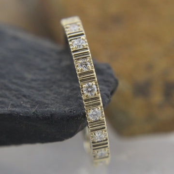 Natural diamond eternity band in 14k gold close-up showing sparkle and micro-pave setting,
Side view of recycled gold eternity band with round diamonds in seamless setting,