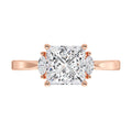 Rose gold ring with a large diamond and smaller diamonds on the band against a white background