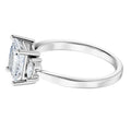 Diamond ring in white gold with a princess shaped center stone on a white background